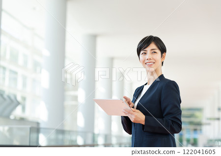 在辦公室使用平板電腦的女商人 在辦公室使用平板電腦的女商人 122041605