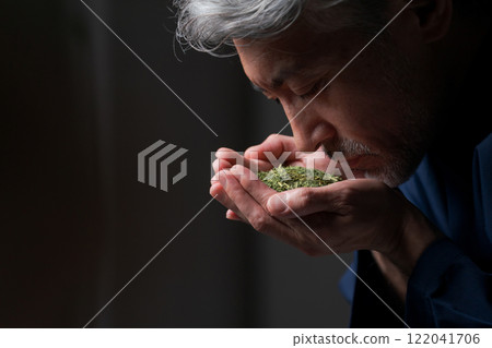 A man in work clothes smelling the aroma of tea A man in work clothes smelling the aroma of tea 122041706