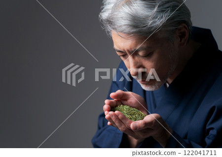 A man in work clothes smelling the aroma of tea A man in work clothes smelling the aroma of tea 122041711