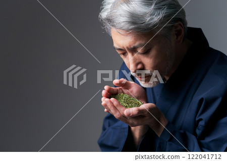 A man in work clothes smelling the aroma of tea A man in work clothes smelling the aroma of tea 122041712