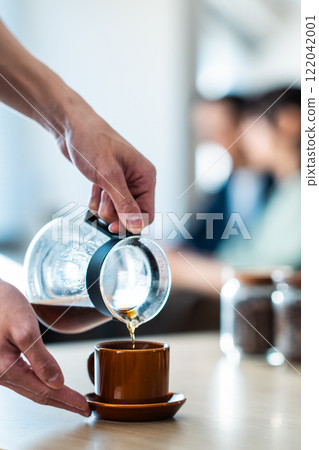 A couple sitting by the window in a cozy cafe 122042001