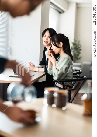 A couple sitting by the window in a cozy cafe 122042003