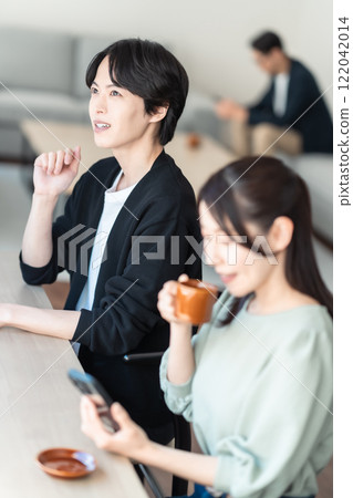 Middle-aged woman having tea at a cafe 122042014