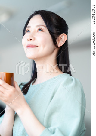 Middle-aged woman having tea at a cafe Middle-aged woman having tea at a cafe 122042015