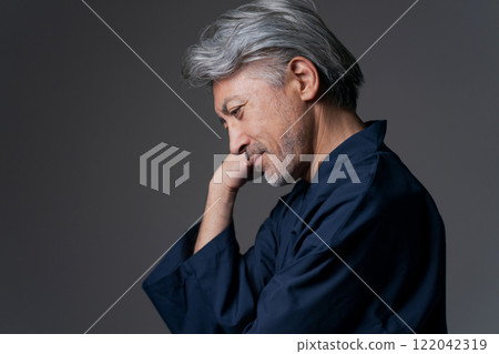 A man in a work uniform with a thinking expression 122042319
