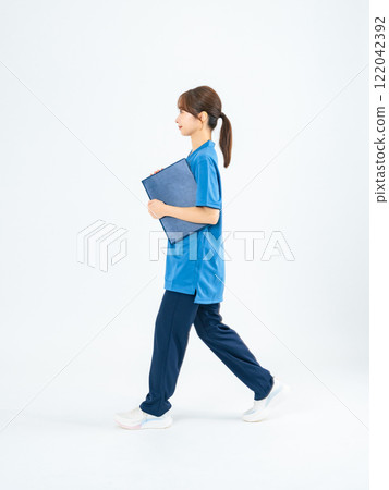 Full-body photo of a woman walking in a scrub, nurse, caregiver 122042392