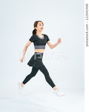 Full body photo of a woman running in sportswear Full body photo of a woman running in sportswear 122042406