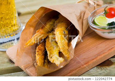 Fish and chips with creamy cheese sauce 122042774