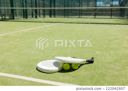 Rackets and balls for playing padel on an outdoor tennis court Rackets and balls for playing padel on an outdoor tennis court 122042807