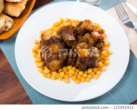 Braised oxtails with chickpeas on a white plate Braised oxtails with chickpeas on a white plate 122042952