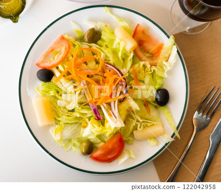 Fresh mixed salad with lettuce, cabbage, carrots, onions, tomatoes, olives. Spanish dish ensalada variada Fresh mixed salad with lettuce, cabbage, carrots, onions, tomatoes, olives. Spanish dish ensalada variada 122042958