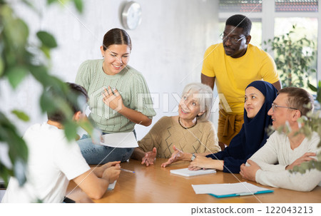 Group of multinational people discussing documents at table 122043213