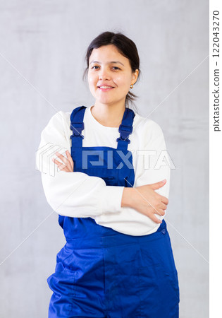 Positive young woman cleaning service worker in blue uniform Positive young woman cleaning service worker in blue uniform 122043270