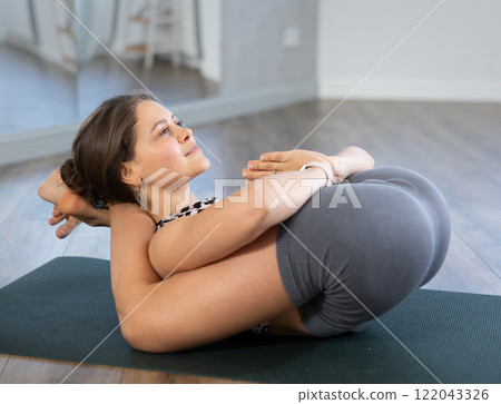 Lover of active lifestyle on yoga mat perform doing yoganidrasan in gym 122043326