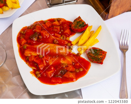 Tilapia fillet with vegetables, french fries and sun-dried tomatoes 122043380