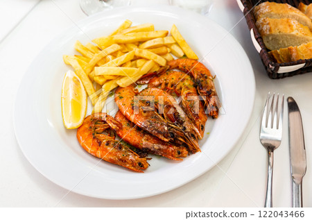 Appetizing baked shrimps with lemon and french fries 122043466