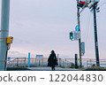 Back view of a woman walking across a crosswalk towards the sea 122044830