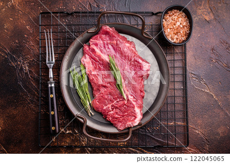 Raw hanger tender beef steak, skirt steak with rosemary on steel tray. brown background. top view 122045065
