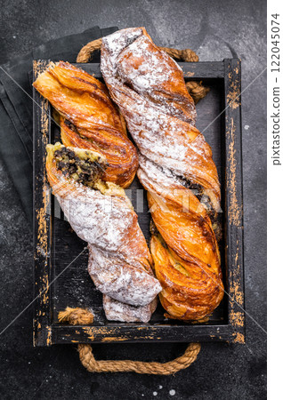 Roll pastry with Pistachios and chocolate, Danish Puff pastry. black background. top view 122045074