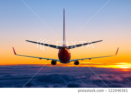 Rear view of a flying passenger jetliner in the sunset sky Rear view of a flying passenger jetliner in the sunset sky 122046361