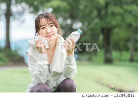 Profile of an Asian woman taking a break after hydrating while exercising/walking 122046811