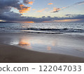 A beautiful tropical sunset and a sandy beach with the sky reflected in it 122047033