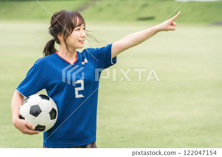 一位日本女性，她是一名足球迷和支持者，指著球門 122047154