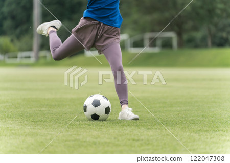 The feet of a woman who kicks and shoots a soccer ball The feet of a woman who kicks and shoots a soccer ball 122047308