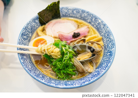 Salty seafood ramen topped with spring onions, clams, and boiled eggs. 122047341