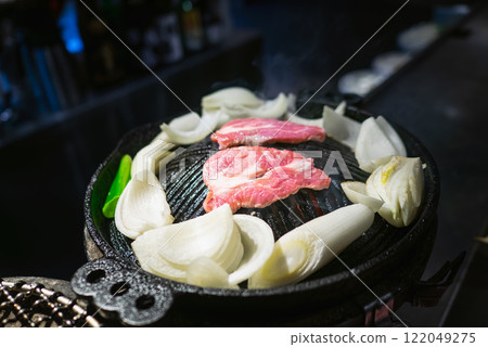 成吉思汗是一道用羊肉製成的燒烤菜餚。羊肉和蔬菜都是在鐵鍋裡烤的。 。 成吉思汗是一道用羊肉製成的燒烤菜餚。羊肉和蔬菜都是在鐵鍋裡烤的。 。 122049275
