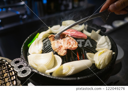 Genghis Khan is a barbecue dish made with lamb. The lamb and vegetables are grilled in an iron pot. 122049276