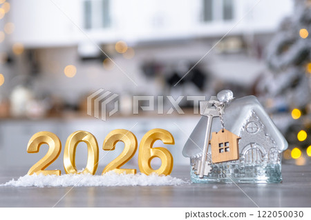 Golden number 2026, key and tiny home on background of cozy white kitchen with Christmas tree and Christmas decor with garland lights. Housing, interior, renovation, mortgage, rent in New Year Golden number 2026, key and tiny home on background of cozy white kitchen with Christmas tree and Christmas decor with garland lights. Housing, interior, renovation, mortgage, rent in New Year 122050030
