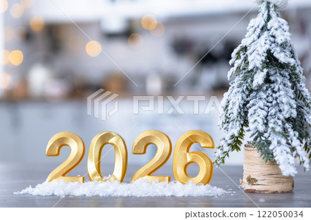 Golden number 2026 on table in background of cozy white kitchen with Christmas tree and Christmas decor with garland lights. Housing, interior, renovation, mortgage, rent in New Year Golden number 2026 on table in background of cozy white kitchen with Christmas tree and Christmas decor with garland lights. Housing, interior, renovation, mortgage, rent in New Year 122050034
