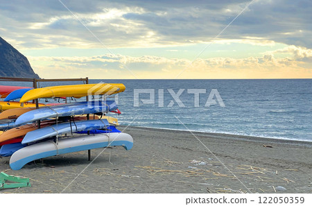 Multi-colored kayak boats on seashore. Nature and sport. Health and tourism. 122050359