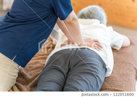 The hands of a female massage therapist and physical therapist massaging a senior woman The hands of a female massage therapist and physical therapist massaging a senior woman 122051600