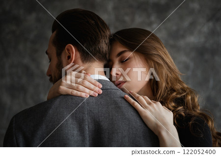 Tender embrace of lovers, a man stands with his back to the camera, women's hands are visible Tender embrace of lovers, a man stands with his back to the camera, women's hands are visible 122052400