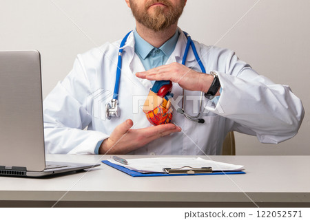 Doctor with anatomical model of human heart Cardiologist supports the heart. heart diagnose medical checkup cardiologist in examination room. Doctor with anatomical model of human heart Cardiologist supports the heart. heart diagnose medical checkup cardiologist in examination room. 122052571