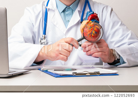 Doctor consult patient on laptop with anatomical model of human heart Cardiologist supports the heart Online doctor appointment. Doctor consult patient on laptop with anatomical model of human heart Cardiologist supports the heart Online doctor appointment. 122052693