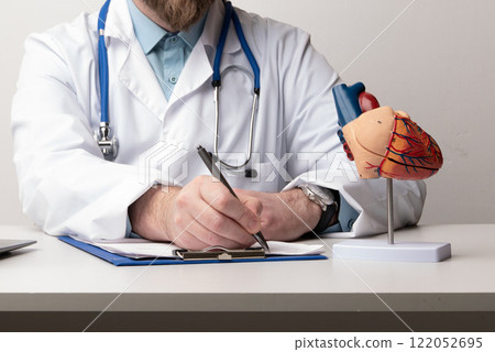 Doctor consult patient on laptop with anatomical model of human heart Cardiologist supports the heart Online doctor appointment. 122052695