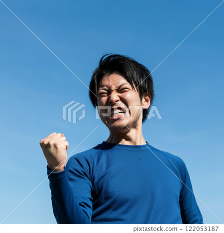 A young Japanese man clenching his fist and getting pumped up 122053187