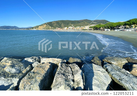Waves of azure sea and stones. Sunny weather. Vacation in Liguria. Nature and meditation. Mountains and sun in summer. Waves of azure sea and stones. Sunny weather. Vacation in Liguria. Nature and meditation. Mountains and sun in summer. 122053211