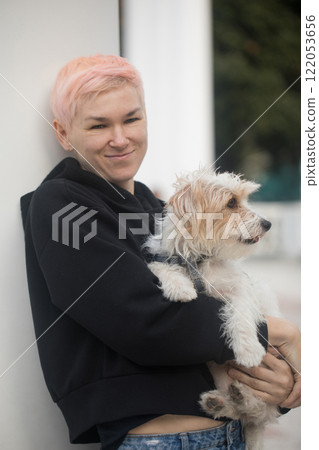 Portrait of affectionate mature woman embracing pet dog Jack Russell Terrier in nature Portrait of affectionate mature woman embracing pet dog Jack Russell Terrier in nature 122053656