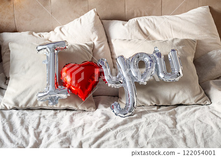 Balloon shaped "i love you" on the bed. 122054001