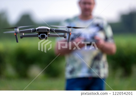 drone copter flying in the air with blurred man on background 122054201