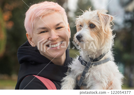 Happy woman having fun playing with pet dog outdoors Happy woman having fun playing with pet dog outdoors 122054377