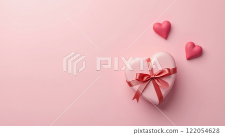 Heart-shaped gift box with ribbon and decorative hearts on a soft pink background 122054628