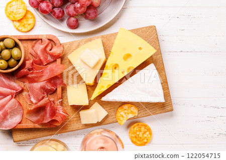 A delectable arrangement of various cheeses, fresh grapes, prosciutto and wine 122054715