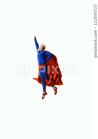 A man in blue superhero costume and red cape flying upward with fist raised, showcasing energy, determination, and personal achievement A man in blue superhero costume and red cape flying upward with fist raised, showcasing energy, determination, and personal achievement 122056723