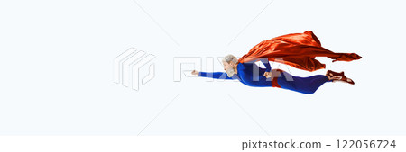 Gray-haired superhero in blue and red costume flies confidently with extended fist, cape flowing dynamically against white studio background 122056724