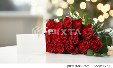 A beautiful bouquet of red roses with a handwritten Valentine Day card, displayed on a white table with elegant lighting. 122056765
